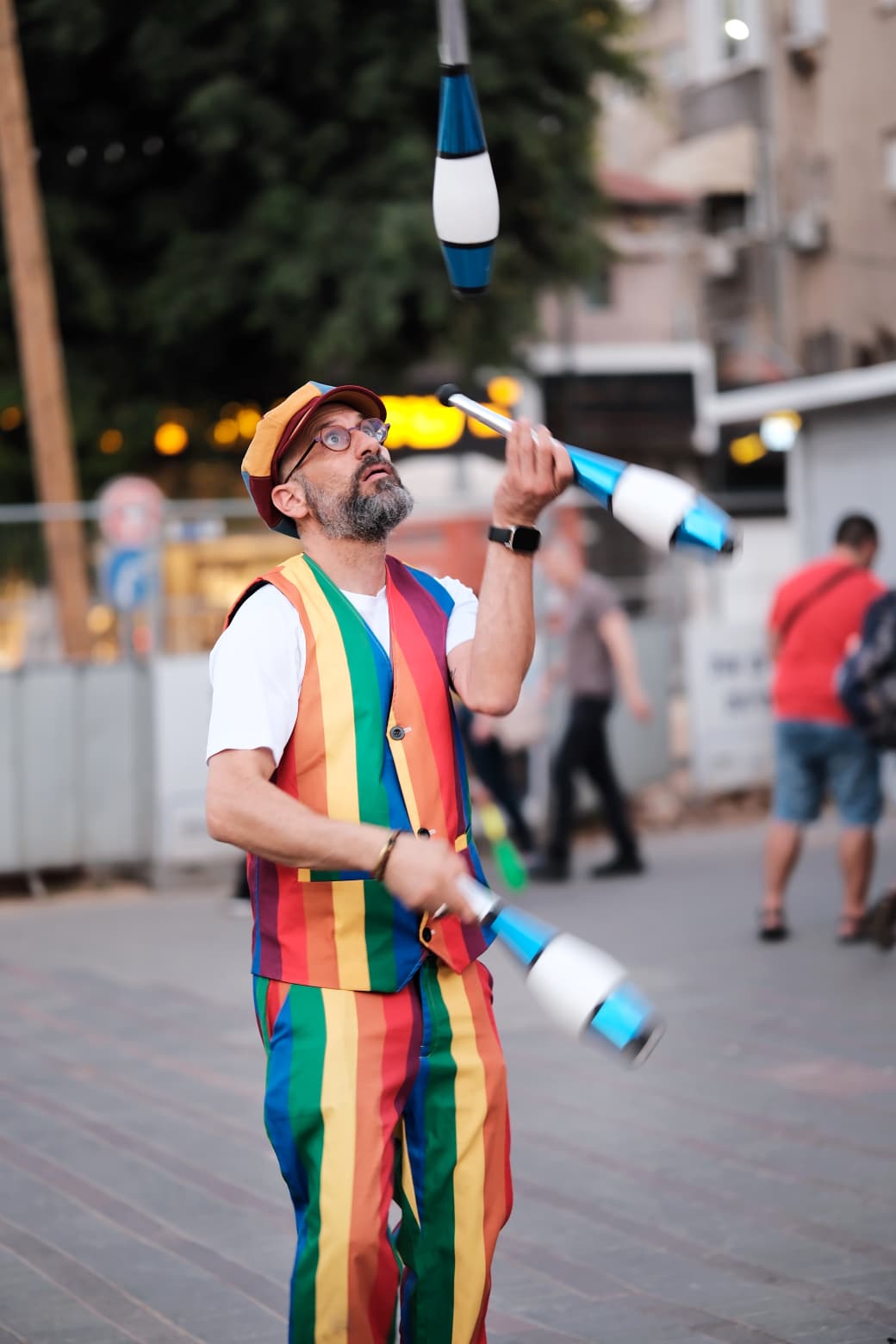גיא מצחיקול מלהטט באלות במופע רחוב
